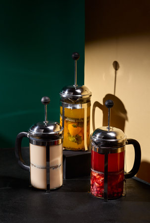 Artisanal tea blends artistically arranged with berries, fruits, and natural purÃ©es, set against a color-blocked black and beige backdrop.の写真素材