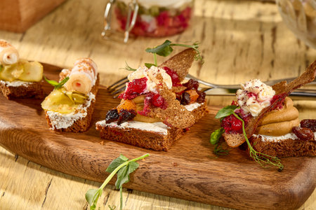 Assorted mini sandwiches with pork fat and pÃ¢tÃ©, served on a rustic Russian table.の写真素材