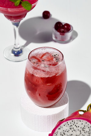 An exotic lemonade with pitaya fruit, staged on a white pedestal against a contrasting blue and white background.の写真素材