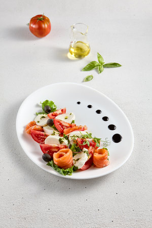 Salmon and mozzarella Caprese salad with fresh tomatoes, top view. Ideal for culinary magazines and healthy eating blogs.の写真素材