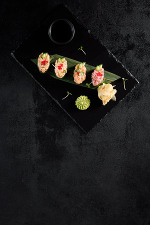 Elegant spicy sushi assortment with salmon, shrimp, tuna, and eel, top view on dark slate.の写真素材
