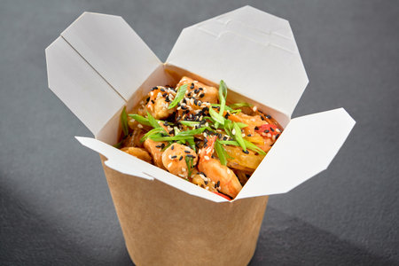Delicious rice glass noodles with chicken fillet served in a takeaway box, perfect for a quick Asian meal.の写真素材