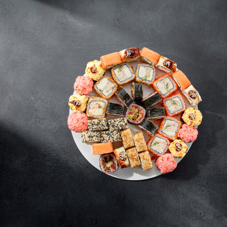 Classic and baked sushi rolls assortment; Philadelphia rolls topped with spicy sauce, a mix of warmth and tradition.の写真素材