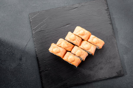 Baked Philadelphia sushi rolls with spicy sauce, offering a creamy and tangy taste in each bite.の写真素材