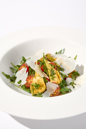 Artichoke and tomato salad with shaved Parmesan cheese.の写真素材