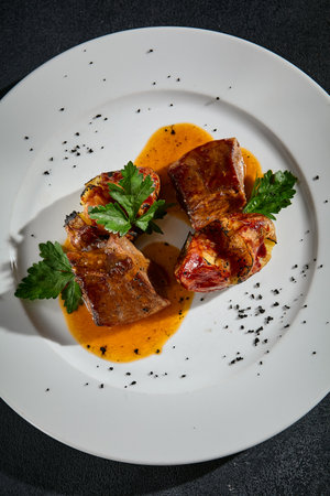 Top view of beef tongue with roasted potatoes on a white plate.の写真素材