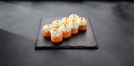 Deluxe Philadelphia rolls wrapped in salmon and topped with a dollop of cream cheese, a luxurious sushi treat.の写真素材