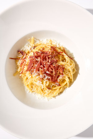 Top View of Classic Italian Carbonara Pasta with Bacon, Cheese, and Egg Yolks, Perfect for High-End Culinary Magazines.の写真素材