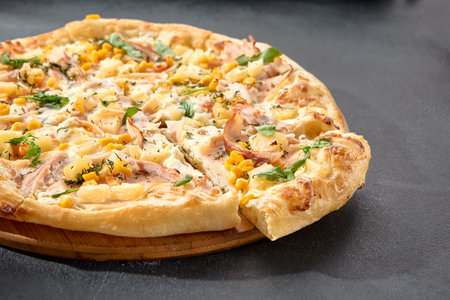 Hawaiian pizza with chicken, pineapple, and corn, a sweet and savory combination on a perfectly baked crust.の写真素材