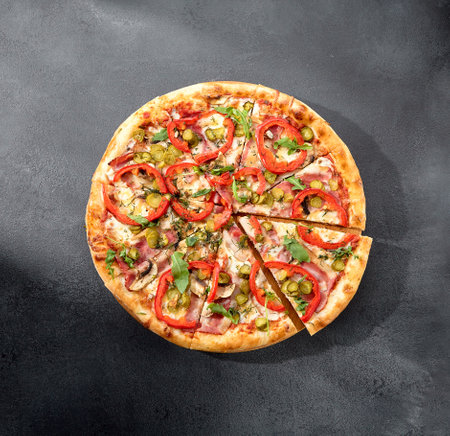 Meat lovers' pizza with bacon, ham, marinated pickles, and paprika, bursting with flavors and toppings.の写真素材
