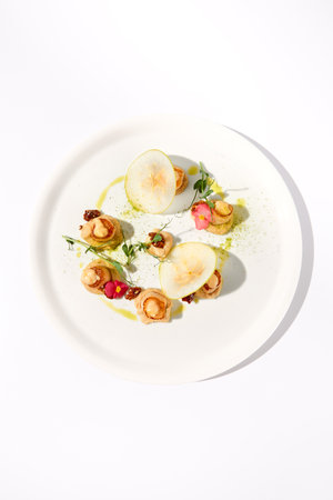 Top View of Seared Sea Scallops with Apple and Celery Puree on White.の写真素材