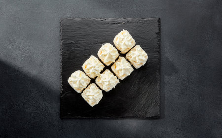 Cheese roll wrapped in cheese and adorned with cream cheese caps; a double cheese sensation in a sushi roll.の写真素材