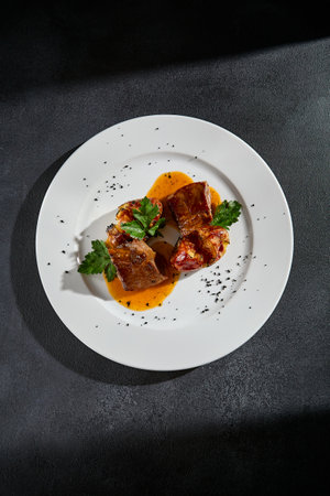 Top view of beef tongue with roasted potatoes on a white plate.の写真素材