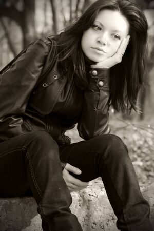 portrait of a pensive girl sitting on the groundの写真素材