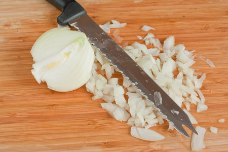 The hands cutting onions on a chopping board