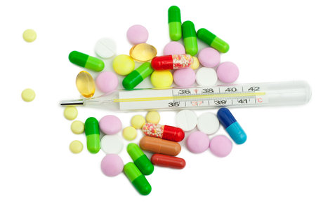 isolated thermometer and pills on white background