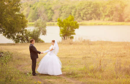 Romantic wedding couple having fun together outdoor in natureの写真素材