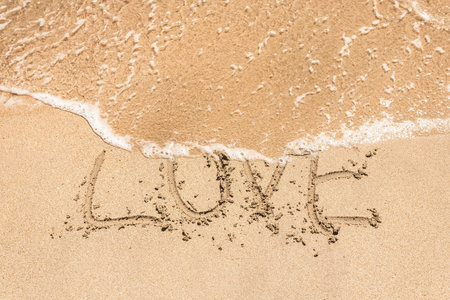 Love handwritten in sand for natural, symbol,tourism or conceptual designsの写真素材