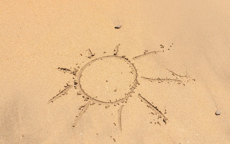 Sun Hollidays Written in the Sand on a Beach with Drawing of the Sun and Sea in Backgroundの写真素材