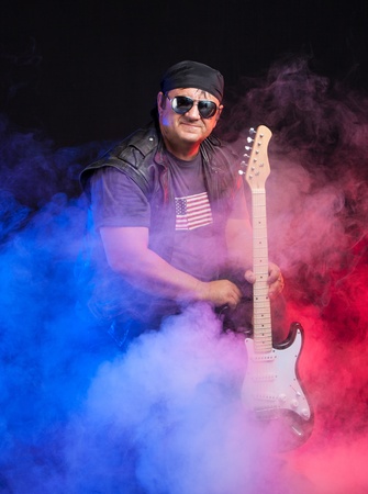 old school rock musician is playing electrical guitar  Shot in a studio の写真素材