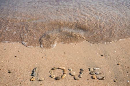 New Year 2014 is coming concept - inscription 2013 and 2014 on a beach sand, the wave is starting to cover the digits 2013の写真素材