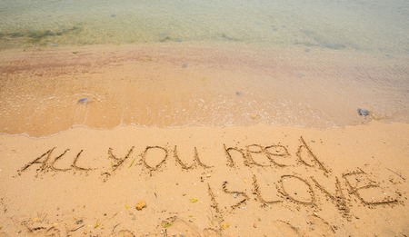 All you need is love written in the sand on the beach.の写真素材