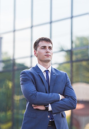 Portrait of a young businessman standing over blurred outdoorsの写真素材