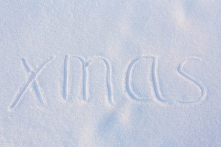 Christmas message written in the snow with decorationsの写真素材