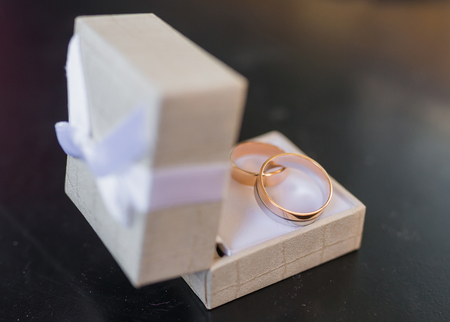 Two wedding rings in a jewelry box on whiteの写真素材