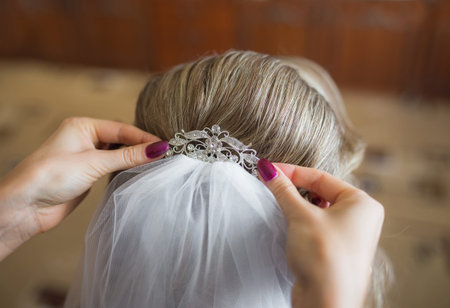 bride getting ready for wedding in hair dressing saloonの写真素材