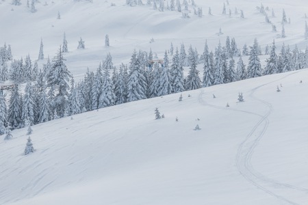 Ski lift with seats going over the mountain and paths from skies and snowboardsの写真素材