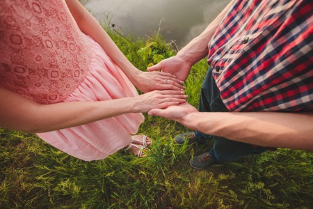 Young couple in love walking in the autumn park holding hands looking in the sunsetの写真素材