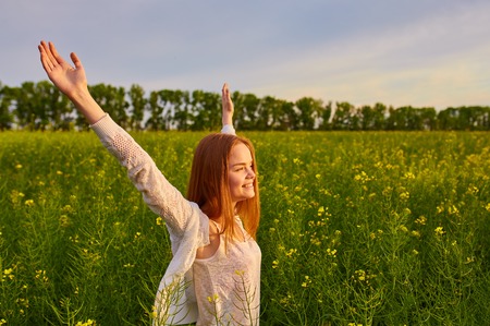 Joyful girl at yellow rape seed meadowの写真素材