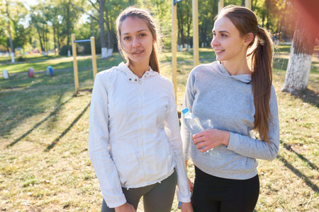Two sports girls stand and rest after morning exercise.
