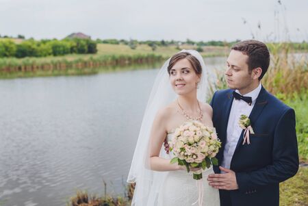 Elegant bride and groom posing together outdoors on a wedding dayの写真素材