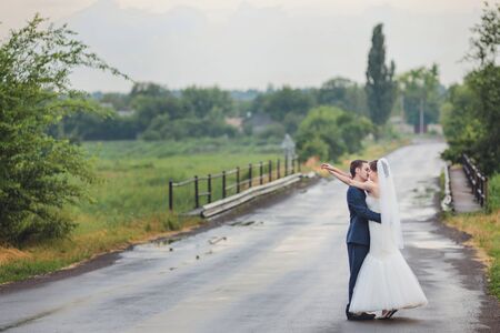 Elegant bride and groom posing together outdoors on a wedding dayの写真素材