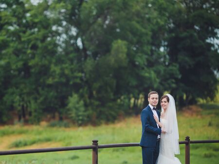 Elegant bride and groom posing together outdoors on a wedding dayの写真素材