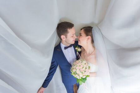 Elegant bride and groom posing together outdoors on a wedding day
