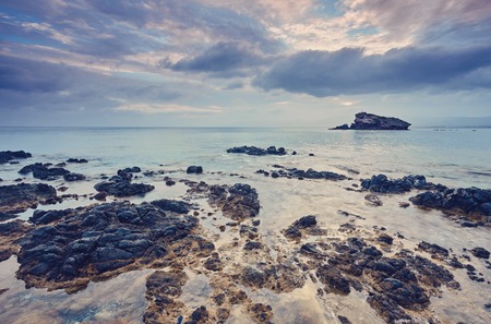 Stones and rocks in forefront with creamy surf ebbing and flowing on Polis beach, Cyprus. Background contains more shoreline and Troodos mountains on horizon.の写真素材