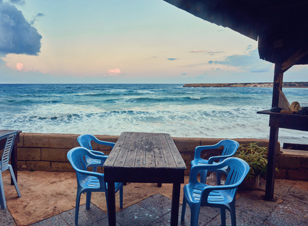 Tables and chairs in a cafe with palm trees on the beach Lara, Cyprusの写真素材