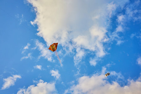 Kite flying in the sky among the cloudsの写真素材