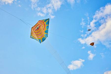 Kite flying in the sky among the cloudsの写真素材