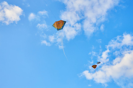 Kite flying in the sky among the cloudsの写真素材