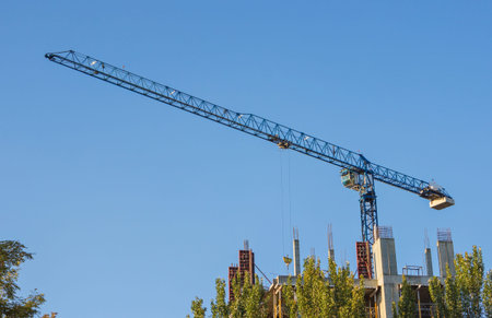 High-rise building construction site with cranes against blue skyの写真素材