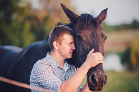 young man and a horse in the forestの写真素材