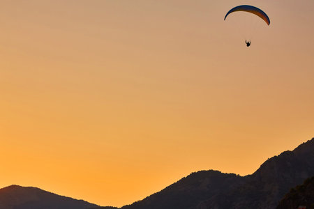 Silhouette Of Paragliders Against Dramatic Sky At Sunsetの写真素材