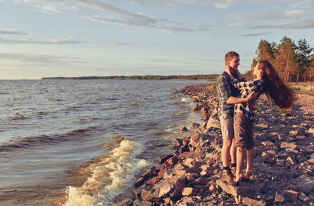 Young couple hugging by the beachの写真素材
