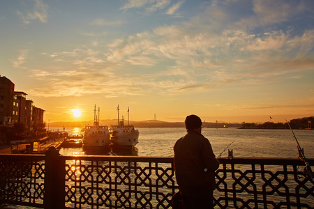Silhouettes of fishermen fishing on Galata Bridge to relax and enjoy their hobby in Istanbul, Turkeyの写真素材