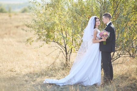 Young wedding couple enjoying romantic moments outside on a summer meadowの写真素材