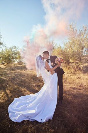 couple in wedding attire with a bouquet of flowers and greenery is in the handsの写真素材